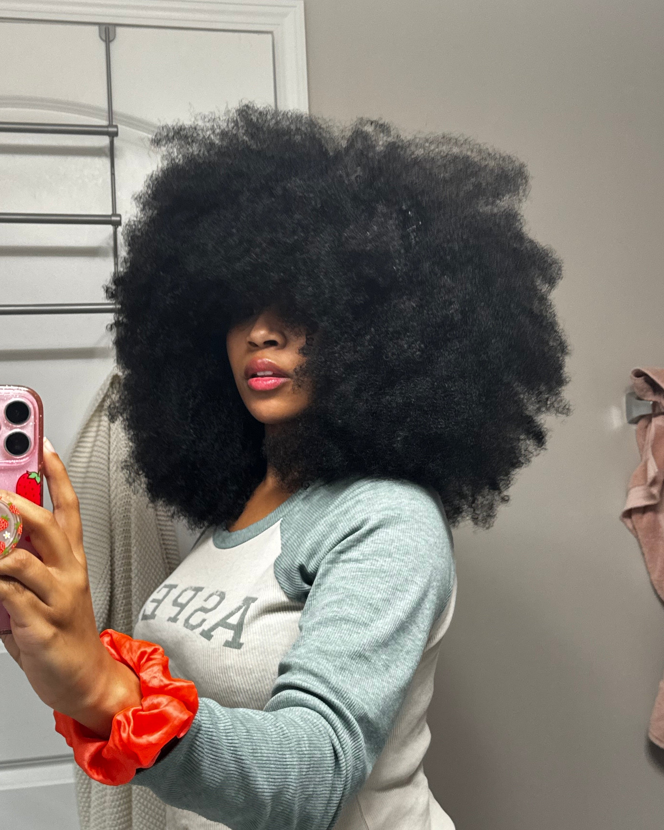 Person with an afro taking a selfie in a room.